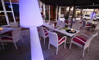 a patio with a table and chairs , as well as a lamp and several potted plants at Alegria