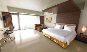 a large , modern bedroom with a king - sized bed and a sliding glass door leading to a balcony at Sakura Park Hotel & Residence