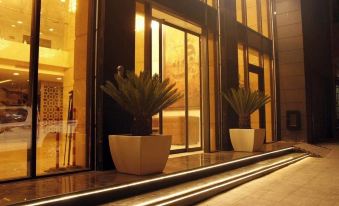 a hotel entrance with two potted plants on the glass doors , creating a warm and inviting atmosphere at Sofi Hotel