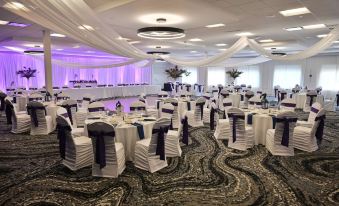 a large banquet hall filled with tables and chairs , ready for a formal event or wedding reception at DoubleTree by Hilton Pittsburgh Monroeville Convention Center