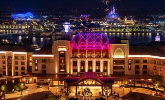 At dusk, there is a captivating night view of the city with illuminated red buildings at Shanghai Disneyland Hotel