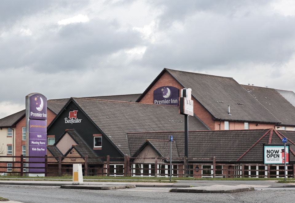 "a large hotel with a sign that reads "" premier inn "" on the side of the building" at Darlington East (Morton Park)