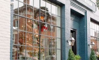 a brick building with a window display of various potted plants and flowers , creating a welcoming atmosphere at The Georges
