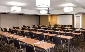 a large conference room with rows of chairs arranged in a semicircle , and a projector screen mounted on the wall at Wyndham Avon