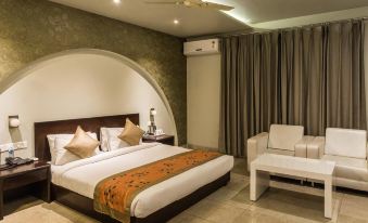 a modern hotel room with a large bed , white couch , and an orange throw blanket at The Opal