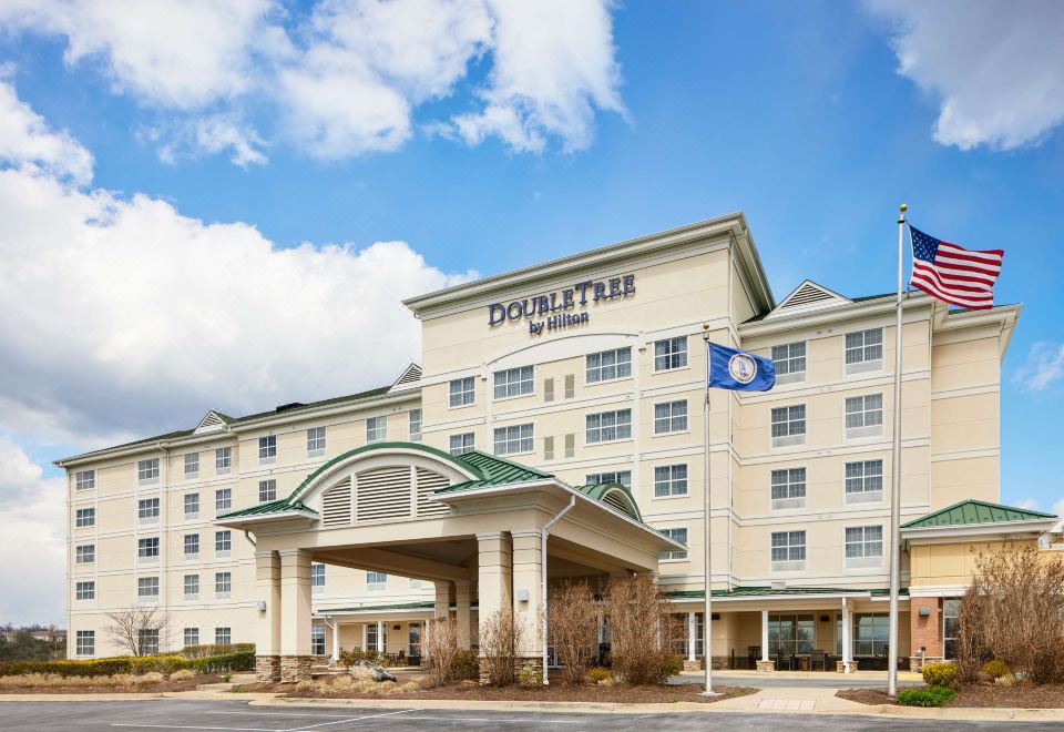 a doubletree by hilton hotel with its sign , surrounded by trees and a blue sky at DoubleTree by Hilton Front Royal Blue Ridge Shadows