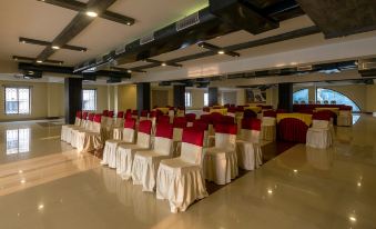 a large conference room with rows of chairs arranged in a semicircle , ready for an event at The Loft Hotel, Siliguri