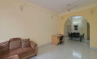 a spacious living room with a brown couch , dining table , and chairs , as well as a kitchen in the background at Radical