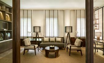 a modern living room with a gray couch , brown chair , and two lamps on either side of the couch at Anantara Hua Hin Resort