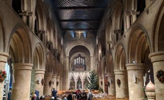 a large , open church with arched ceilings and wooden pews filled with people standing in the aisle at Bridleways Guesthouse & Holiday Homes