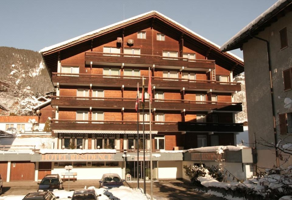 a large wooden building with multiple floors , possibly a hotel or hotel or resort , situated in a snowy environment at Hotel Residence