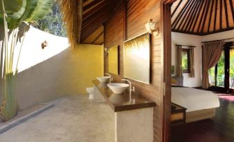 a bathroom with two sinks , a mirror , and a wooden wall under a thatched roof at Mali Resort Pattaya Beach Koh Lipe