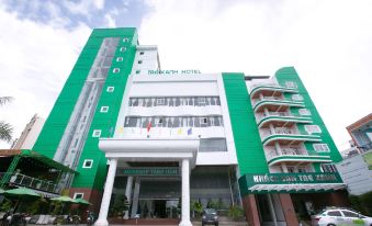 "a green and white building with a sign that reads "" hotel thankathi "" prominently displayed on the front" at Tre Xanh Hotel