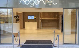 "a modern building entrance with a sign reading "" nogentel "" and a blue carpet on the floor" at Hôtel du Port