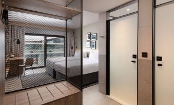 a modern hotel room with two beds , a desk , and a sliding glass door leading to a balcony at Hilton Garden Inn Silverstone