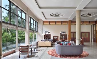 a spacious living room with high ceilings , large windows , and various pieces of furniture such as a couch , chairs , and a dining table at Sheraton Kosgoda Turtle Beach Resort