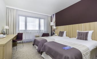 a hotel room with two beds , one on the left and one on the right side of the room at Hotel Mercure Gdynia Centrum