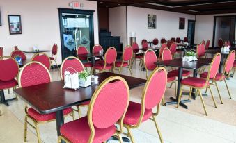 a large dining room with multiple tables and chairs arranged for a group of people to enjoy a meal together at Leisure Inn