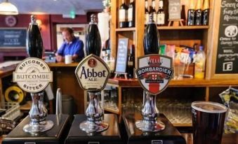 a bar with three beer taps , one of which is being filled with a dark liquid at George Inn