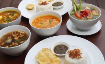 a table is set with various dishes , including soups and snacks , in white bowls and plates at Swiss-Belinn Modern Cikande