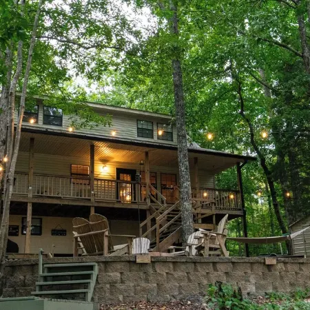 Luxurious cabin with fire pit, kayaks, and dock.
