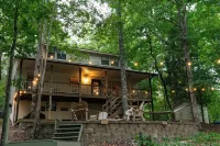 Luxurious cabin with fire pit, kayaks, and dock.