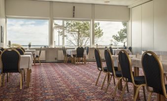 a large dining room with several tables and chairs arranged for a group of people at Hotel Marina