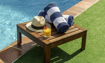 a wooden tray with towels and a hat on it , placed near a swimming pool at Novotel Sydney Darling Harbour