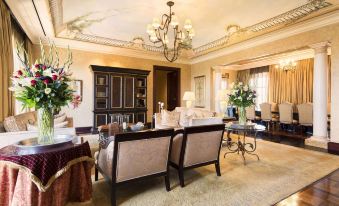 a luxurious living room with elegant furniture , including two chairs and a coffee table , surrounded by large windows at Palazzo Hotel