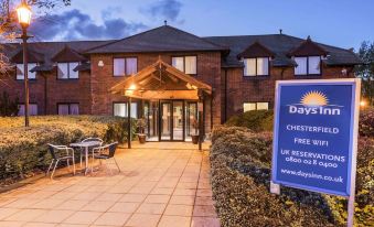"a brick building with a blue sign that reads "" days hotel chester - newbold hotel "" in front of it" at Days Inn by Wyndham Chesterfield Tibshelf