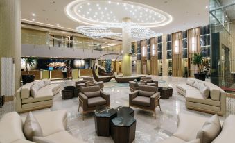 a luxurious hotel lobby with multiple couches , chairs , and tables arranged in an open space at Zuri Hotel