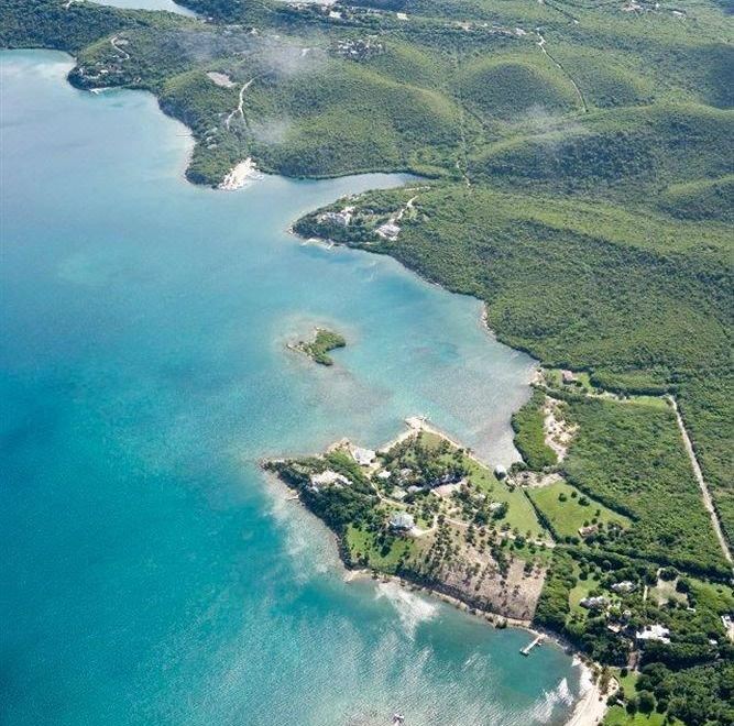 an aerial view of a tropical island with lush greenery , white sand beaches , and clear blue water at Harmony Hall