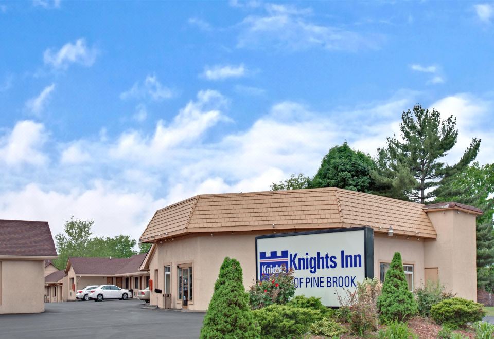 "a large building with a sign that reads "" knights inn of pine brook "" prominently displayed on the front of the building" at Knights Inn Pine Brook