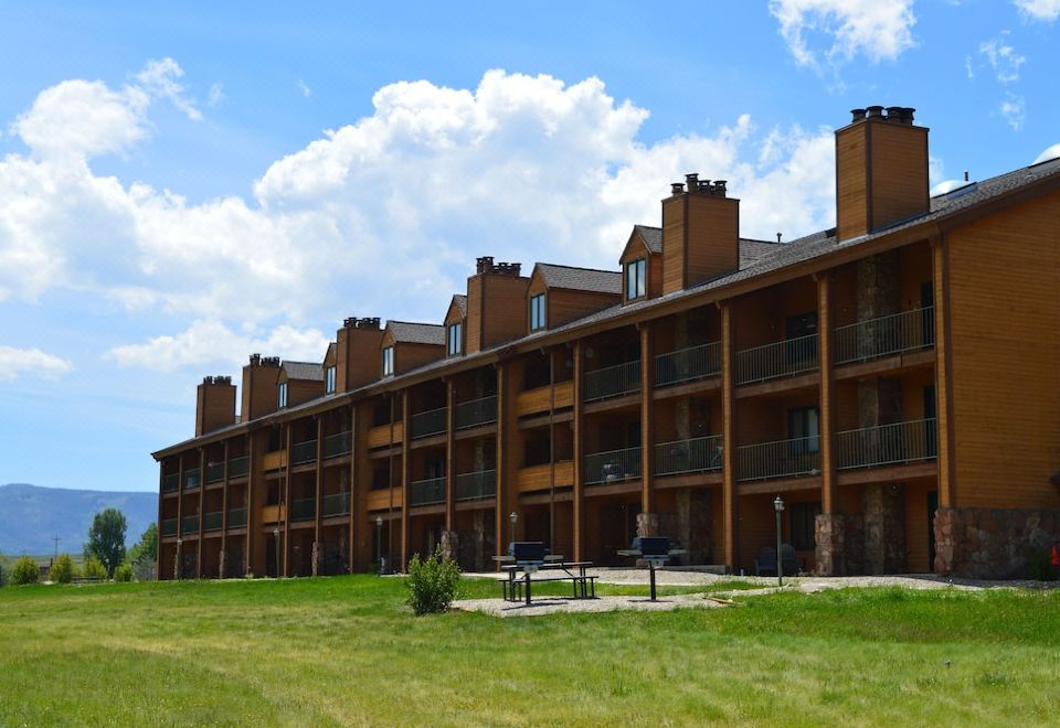 a row of multi - story buildings with balconies and a grassy area in front of them at The Inn at Silvercreek