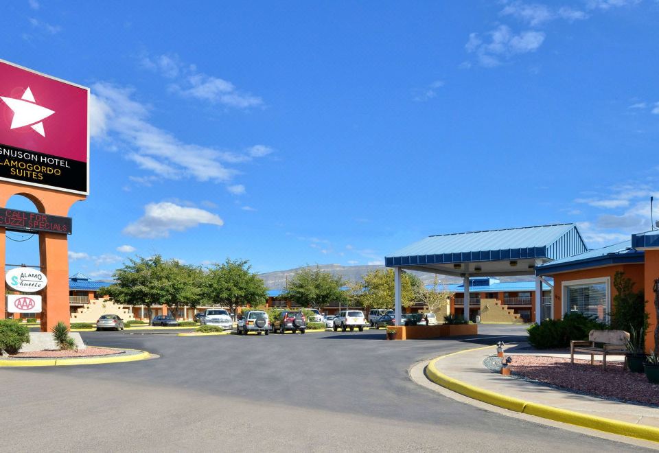 a large , well - maintained parking lot with multiple cars parked in various spots under a clear blue sky at The Classic Desert Aire Hotel