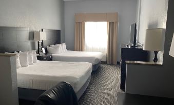 a hotel room with two beds , a chair , and a window , giving a sense of comfort and relaxation at Lakeside Resort & Conference Center