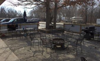 a patio with several chairs and a fire pit , surrounded by trees and parked cars at Hidden Lake Resort