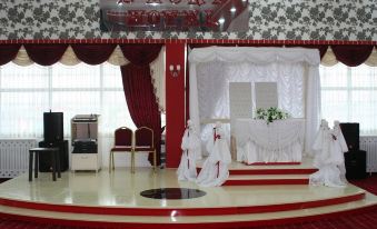 a wedding ceremony taking place in a red and white color scheme , with the bride and groom standing at the altar at Sword Hotel