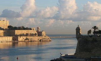 a large body of water with a castle on a hill in the background , creating a serene and picturesque scene at Sunflower Hotel