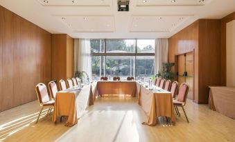 a conference room with a long table , chairs , and a large window overlooking the outdoors at Abba Garden