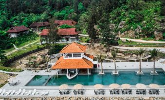 an aerial view of a resort with a large pool surrounded by chairs and tables at Quynh Vien Resort Ha Tinh