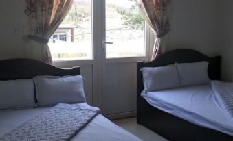 two beds with white sheets and pillows are placed next to each other in a room at Hotel Nguyen Ngoc