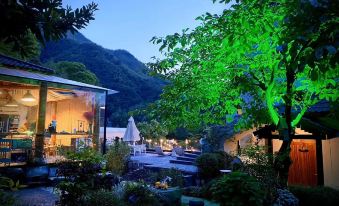 A well-lit house surrounded by illuminated trees in the middle of the night at Little Forest Guesthouse