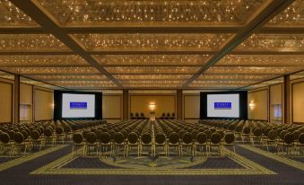 a large conference room with rows of chairs arranged in a semicircle , and two screens on the wall at Hyatt Regency Long Beach