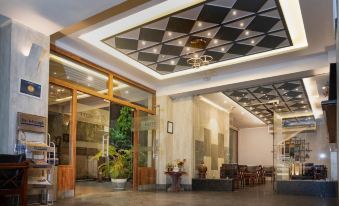 a modern hotel lobby with high ceilings , large windows , and wooden doors , decorated with green plants and plants at The Loft Hotel, Siliguri