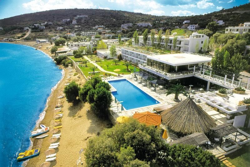 aerial view of a resort with a swimming pool , beach , and surrounding area , including buildings , trees , and a beach at Golden Sand Hotel