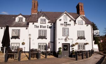 "a white building with a sign that says "" the blue cafe "" and a chimney is shown in the image" at Premier Inn Northwich (Sandiway)