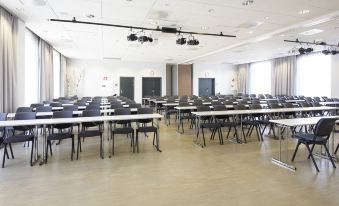 an empty conference room with rows of tables and chairs , ready for a meeting or event at Thon Partner Elgstua Hotel