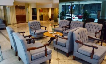 a hotel lobby with several chairs and couches arranged in a seating area , creating a cozy atmosphere at Oxford Hotel