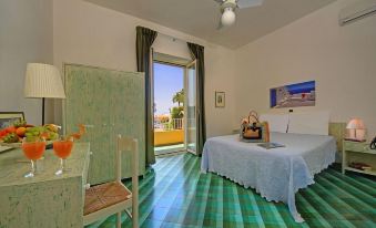 a bedroom with a green and blue checkered floor , a white bed , and a doorway leading to a balcony at Hotel la Luna